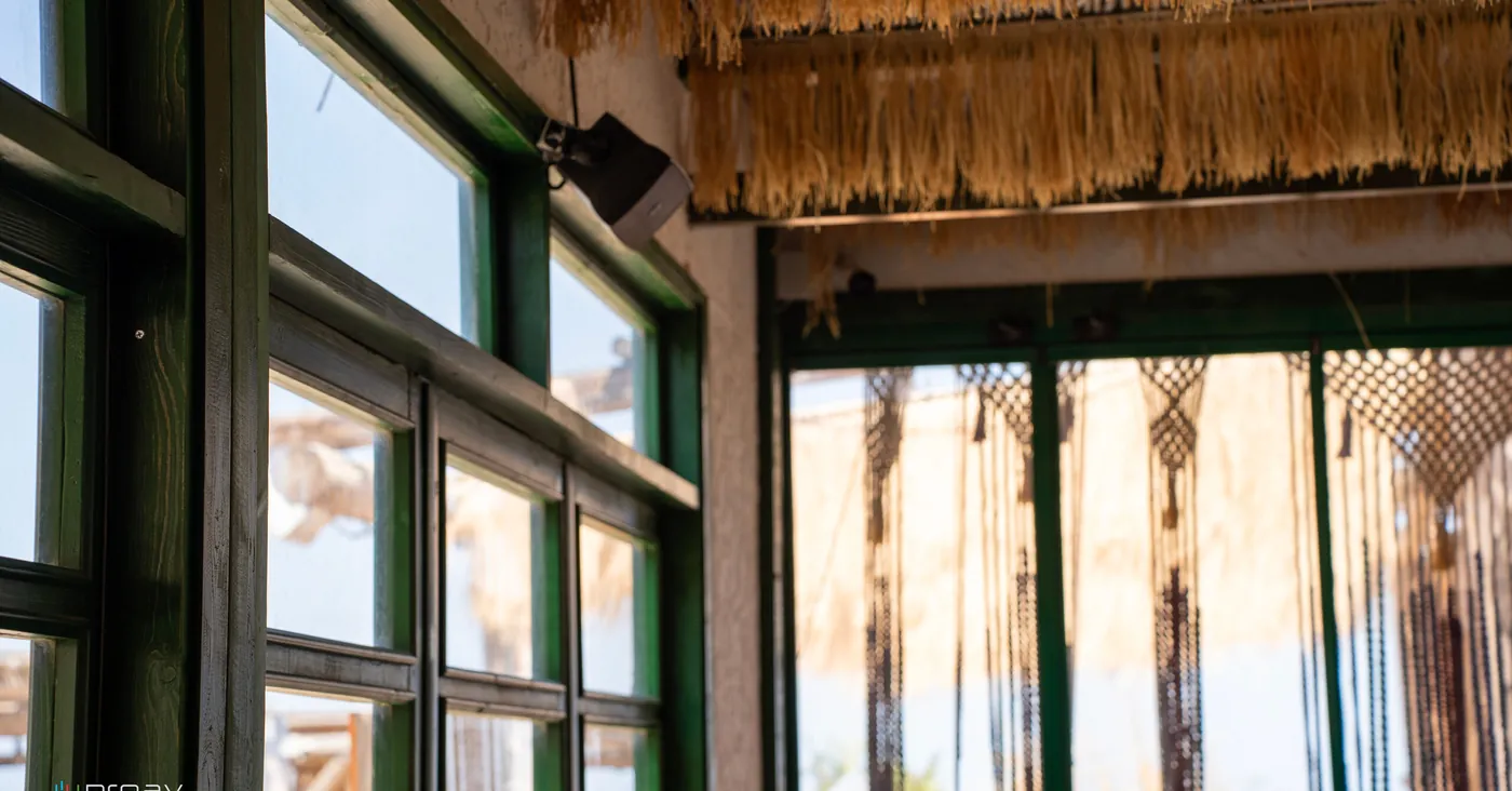 windows in green frames and a macramé curtain